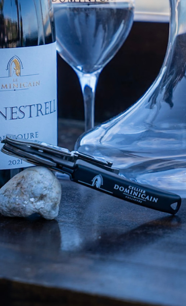 Tire-bouchon sommelier Cellier Dominicain posé devant une bouteille et un verre